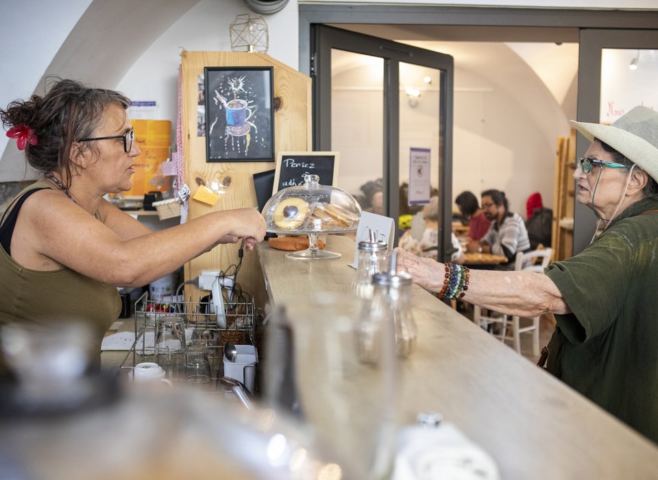 une bénévole derrière le comptoir au café solidaire anais à nimes