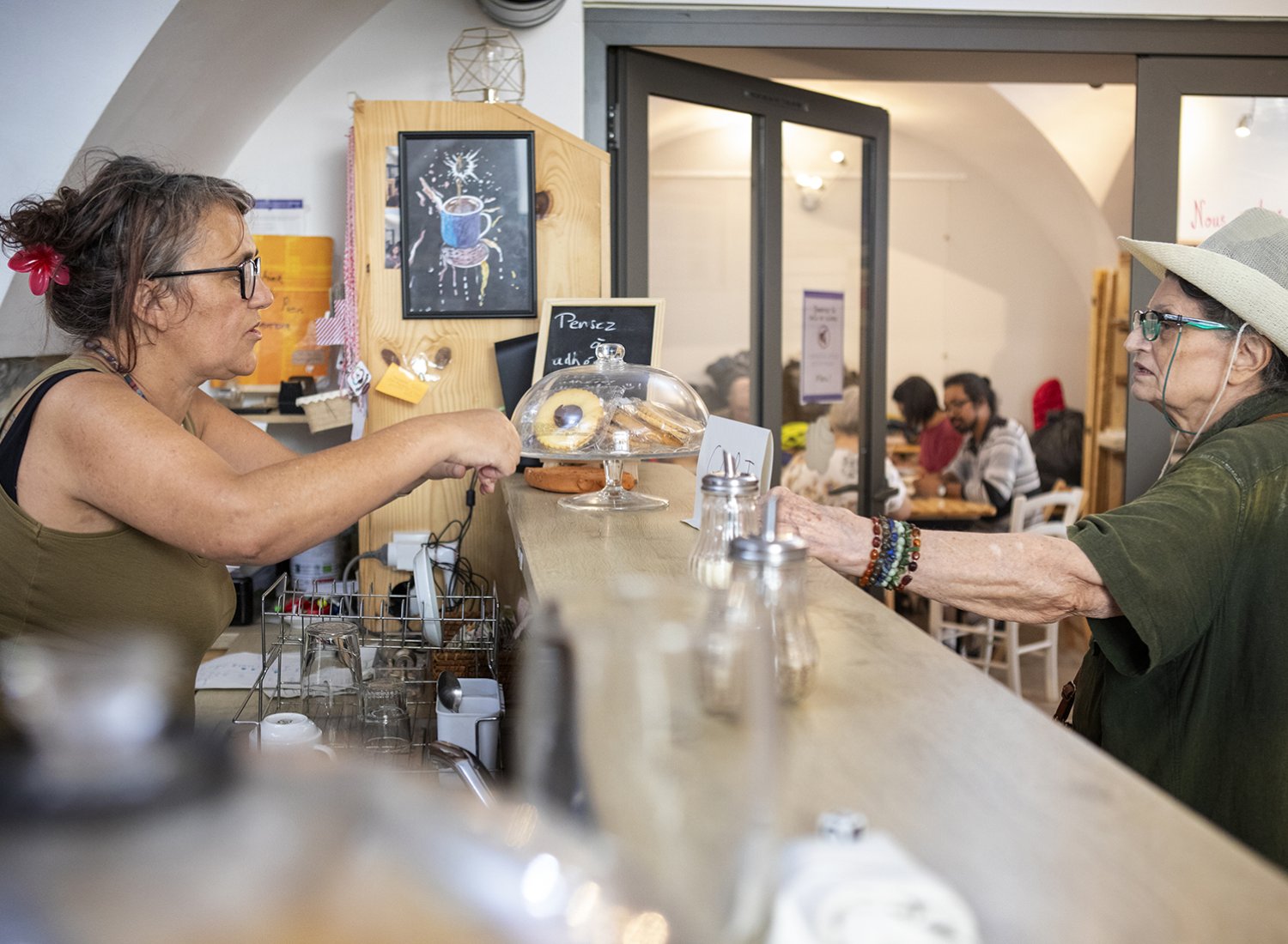 une bénévole derrière le comptoir au café solidaire anais à nimes